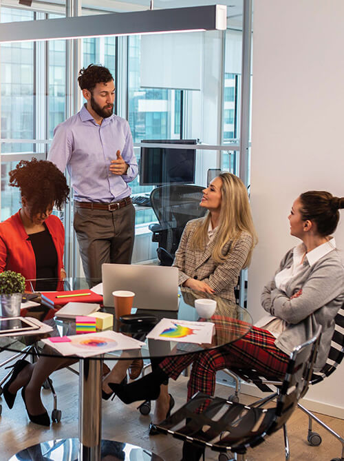 Diverse group of coworkers in an informal meeting, illustrating the importance of inter-departmental  communication.