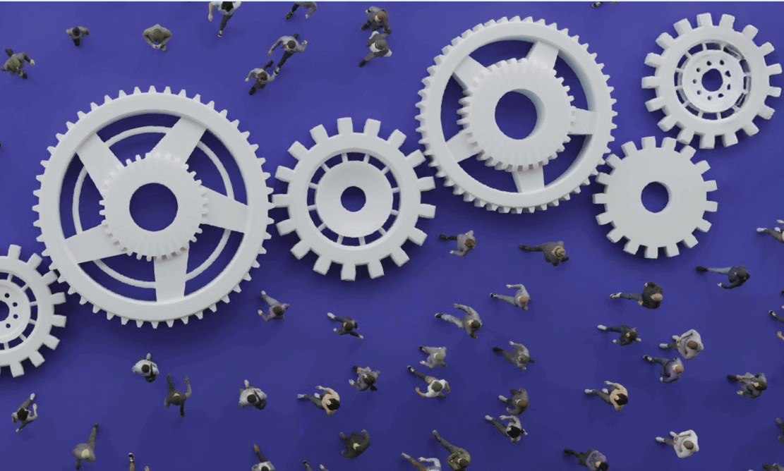People walking beneath large interlocking gears on a blue background, symbolizing the interaction between human activity and integrated systems.