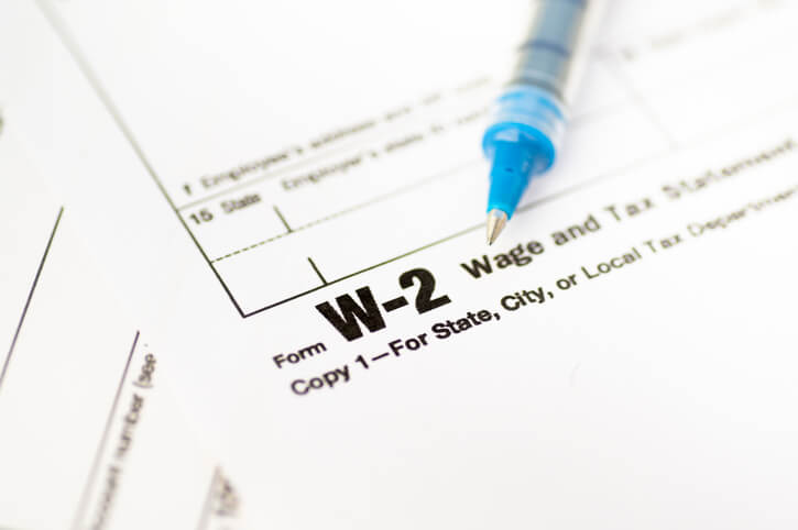 A close-up of a W-2 Wage and Tax Statement form labeled "Copy 1—For State, City, or Local Tax Department," with a blue pen resting on top.