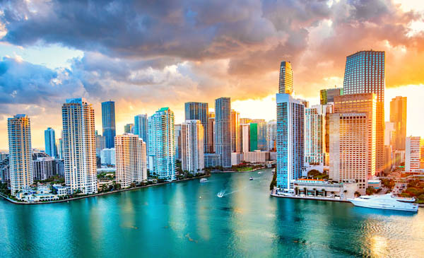 The skyline of Miami, Florida along the Biscayne Bay shot at sunset via helicopter from an altitude of about 500 feet over the bay.