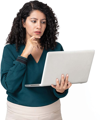 Woman staring pensively at laptop computer she holds in her hand.